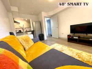 un soggiorno con divano giallo e TV a schermo piatto di Bright & Cosy One Bedroom Apartment - Perfect base in Bishop's Stortford a Bishops Stortford