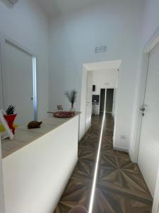 San Ferdinando suite room في نابولي: ممر به جدران بيضاء وأرضيات خشبية