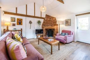 a living room with a couch and a fireplace at The Stables, Hoo in Woodbridge