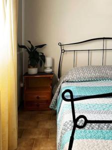sypialnia z łóżkiem i rośliną na komodzie w obiekcie Andros escape - a cosy 1bed flat w mieście Gavrion