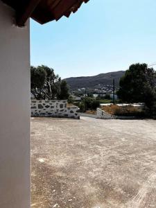 ein Parkplatz mit einem Gebäude mit einem Berg im Hintergrund in der Unterkunft Andros escape - a cosy 1bed flat in Gavrio