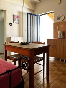 Habitación con mesa de madera y 2 sillas. en Andros escape - a cosy 1bed flat, en Gavrion