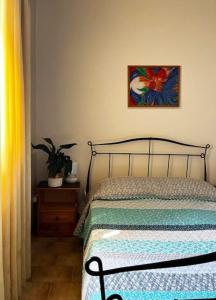 1 dormitorio con 1 cama y una pintura en la pared en Andros escape - a cosy 1bed flat, en Gavrion