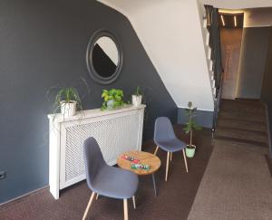 - un couloir avec deux chaises, une table et un miroir dans l'établissement Eibacher Hof, à Nuremberg