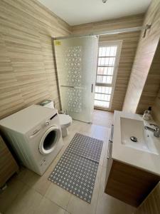 a bathroom with a washing machine and a sink at "Flora B&B "- Rooms in Privat Home in Maspalomas