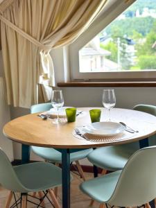 una mesa y sillas con copas de vino y una ventana en Le Mansarde di Siberia, en Craveggia