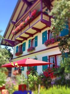 a building with a red umbrella in front of it at Sonnenhof - Ferienwohnung in Oberstaufen