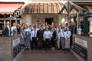 eine Gruppe von Personen, die sich vor einem Gebäude für ein Bild ausgeben in der Unterkunft Inselhotel König in Norderney