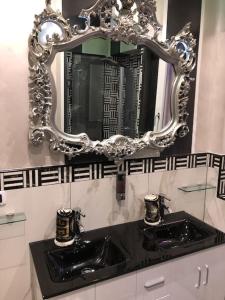 uma casa de banho com dois lavatórios e um espelho na parede em DEVILTHON SUITE NETTUNO em Nettuno
