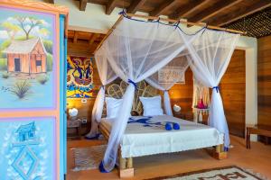 a bedroom with a bed with a canopy at La Plage de Le Zahir in Nosy Be