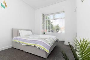 a white bedroom with a bed and a window at Thornaby Road TSAC in Stockton-on-Tees