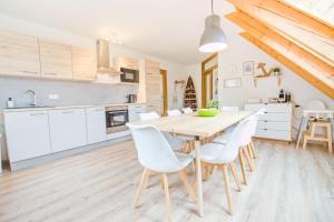 a kitchen and dining room with a wooden table and chairs at Apartmán Riviéra Lipno 510/21 in Lipno nad Vltavou