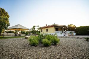 une maison avec un grand parapluie et quelques plantes dans l'établissement Villa Patrizia-Luxury Villa, à Mottola