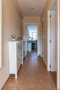 a hallway with white cabinets and a tile floor at Solar Home in Suances