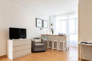 sala de estar con TV y silla en Solar Home en Suances