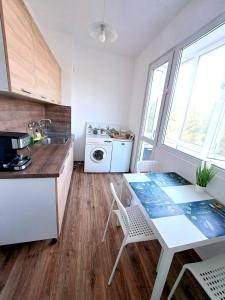 a kitchen with a table and a sink and a washing machine at Lidda Apartment in residential area in Varna City