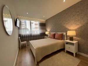 a small bedroom with a bed and a mirror at Alta Lisboa Apartment in Lisbon