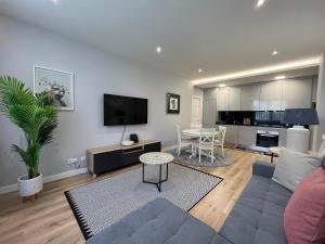 a living room with a couch and a tv and a table at Alta Lisboa Apartment in Lisbon