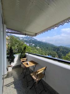 2 stoelen en een tafel op een balkon met uitzicht bij The Garuda Hotel And Spa in Gangtok