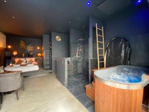 a room with a bath tub and a bed and a ladder at La Shelby avec terrasse privée in Bordeaux