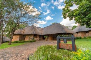 ヘイジービューにあるKruger Park Lodge Unit No 252 with private poolの茅葺き屋根の大きなレンガ造り