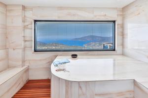 a bathroom with a large window and a white tub at Villa Jilda Kalkan in Kalkan