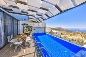 a balcony with a pool and a table and chairs at Villa Jilda Kalkan in Kalkan