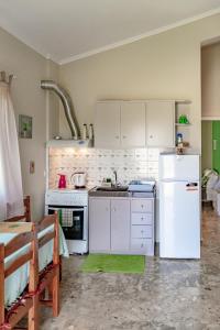 a kitchen with a white refrigerator and a stove at Ritsinia Apartments in Aigio