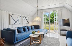 ein Wohnzimmer mit einem blauen Sofa und einem Tisch in der Unterkunft Awesome Home In Ulfborg With Kitchen in Fjand Gårde