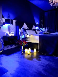 a blue room with a bed and a table with candles at Platin City Apartment in Hamburg