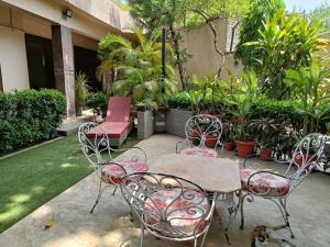 a patio with a table and chairs and plants at Heritage home in Cannaught Place in New Delhi