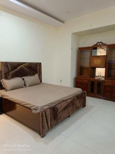 a bedroom with a large bed and a dresser at Heritage home in Cannaught Place in New Delhi