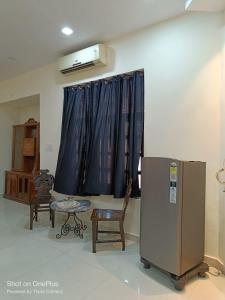 a living room with a refrigerator and a chair at Heritage home in Cannaught Place in New Delhi