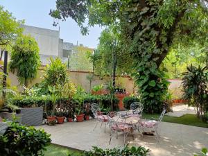 a patio with a table and chairs and plants at Heritage home in Cannaught Place in New Delhi