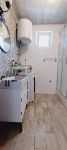 Baño blanco con lavabo y espejo en Apartments TERRAeSAL, en Zadar
