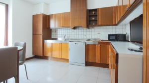 a kitchen with wooden cabinets and a white refrigerator at Italianway - Via Pighini 75 in San Fedele Intelvi