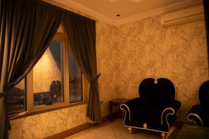 Habitación con silla y ventana en Al Nabarees Al Masi Hotel, en Yeda