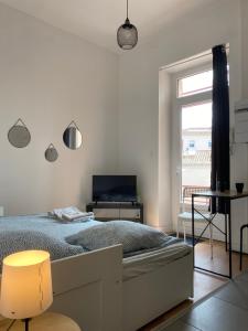 a bedroom with a bed and a desk and a window at LA MAISON D'ANTONIN 2 in Nîmes