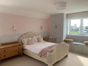 a bedroom with a white bed and a window at Cedar Shade Cottage in Sidmouth