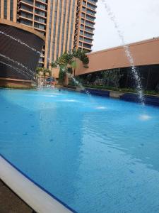 a large swimming pool with a fountain in front of buildings at SAMI APARTMENT - Times Square KL in Kuala Lumpur