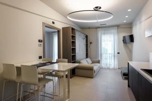 cocina y sala de estar con mesa y sillas en Hotel Il Grappolo D'Oro, en Monforte dʼAlba