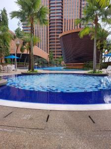 uma grande piscina com palmeiras e um edifício em SAMI APARTMENT - Times Square KL em Kuala Lumpur