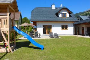 un parque infantil con un tobogán azul en un patio en Chalet Mama, en Pruggern