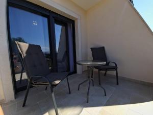 balcón con 2 sillas, mesa y ventana en Luxury Villa Laura en Malinska