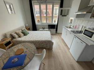 a kitchen and a living room with a bed and a table at Élégant studio rénové in Boulogne-sur-Mer