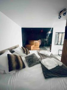 a large white bed with pillows on top of it at La Nordique LE 50 Suites and SPA in Bordeaux