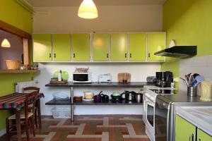 cocina con armarios verdes y fogones horno superior en Gite Au Fil de lEau 