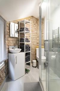 een badkamer met een wastafel, een toilet en een douche bij City Air Apartments - HATTON GARDEN - GREAT TRANSPORT LINKS in Londen