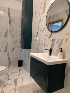 a bathroom with a sink and a mirror at Słoneczne Apartamenty in Ustronie Morskie
