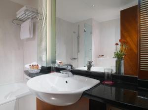 La salle de bains blanche est pourvue d'un lavabo et d'un miroir. dans l'établissement Sheraton Carlton Nuernberg, à Nuremberg